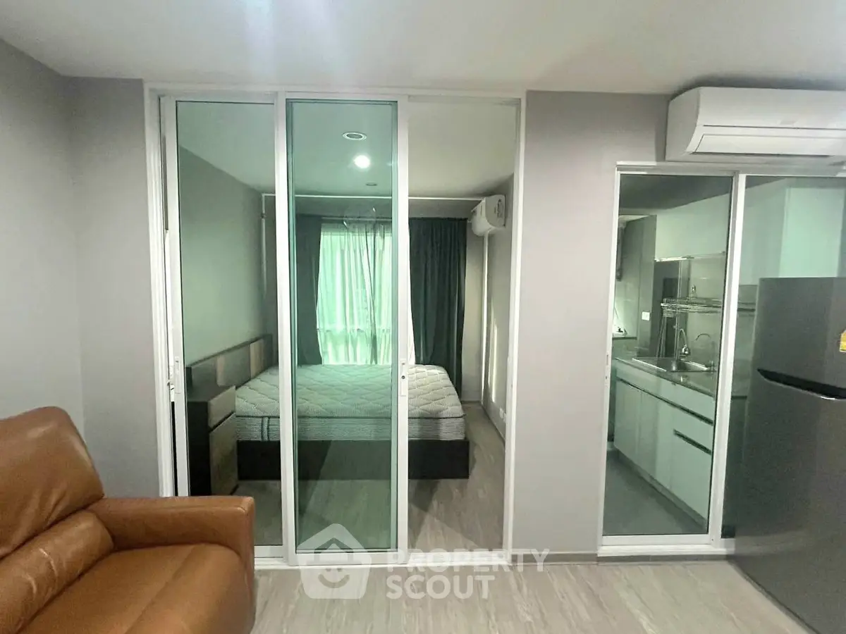 Modern apartment interior with bedroom and kitchen, featuring sleek design and comfortable furnishings.