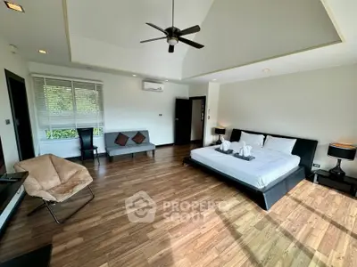 Spacious modern bedroom with elegant wooden flooring and stylish ceiling fan
