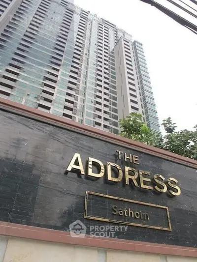 Modern high-rise building exterior with prominent signage at The Address Sathorn.