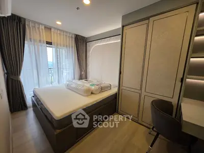 Modern bedroom with large window and stylish furniture