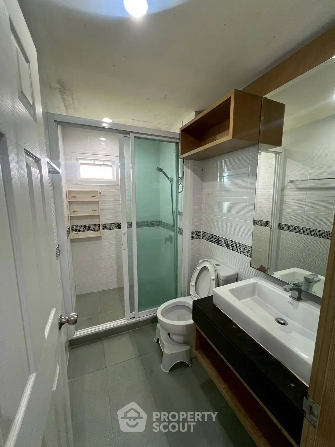 Modern bathroom with glass shower and sleek vanity in a contemporary home.