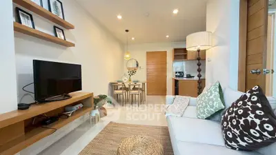 Modern living room with open kitchen, stylish decor, and cozy seating area in a contemporary apartment.