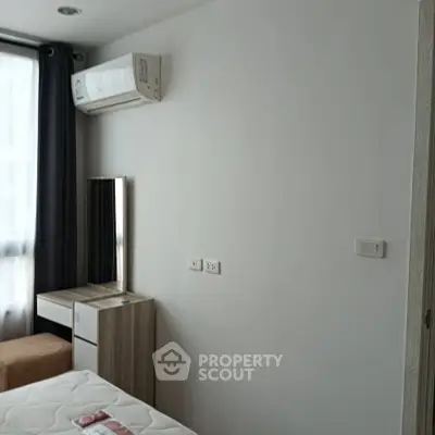 Modern bedroom with air conditioning and natural light, featuring a sleek vanity and comfortable bed.