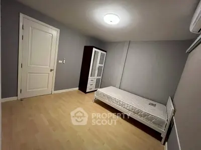 Minimalist bedroom with single bed and wardrobe in modern apartment.