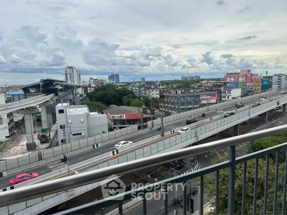 Stunning urban view from a high-rise balcony overlooking cityscape and highways.