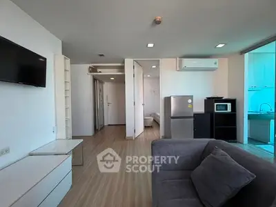 Modern living room with sleek furniture and open kitchen layout in a stylish apartment.