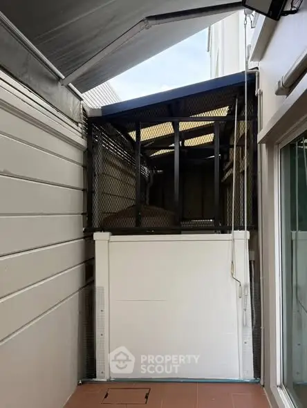 Compact outdoor elevator on a modern residential balcony