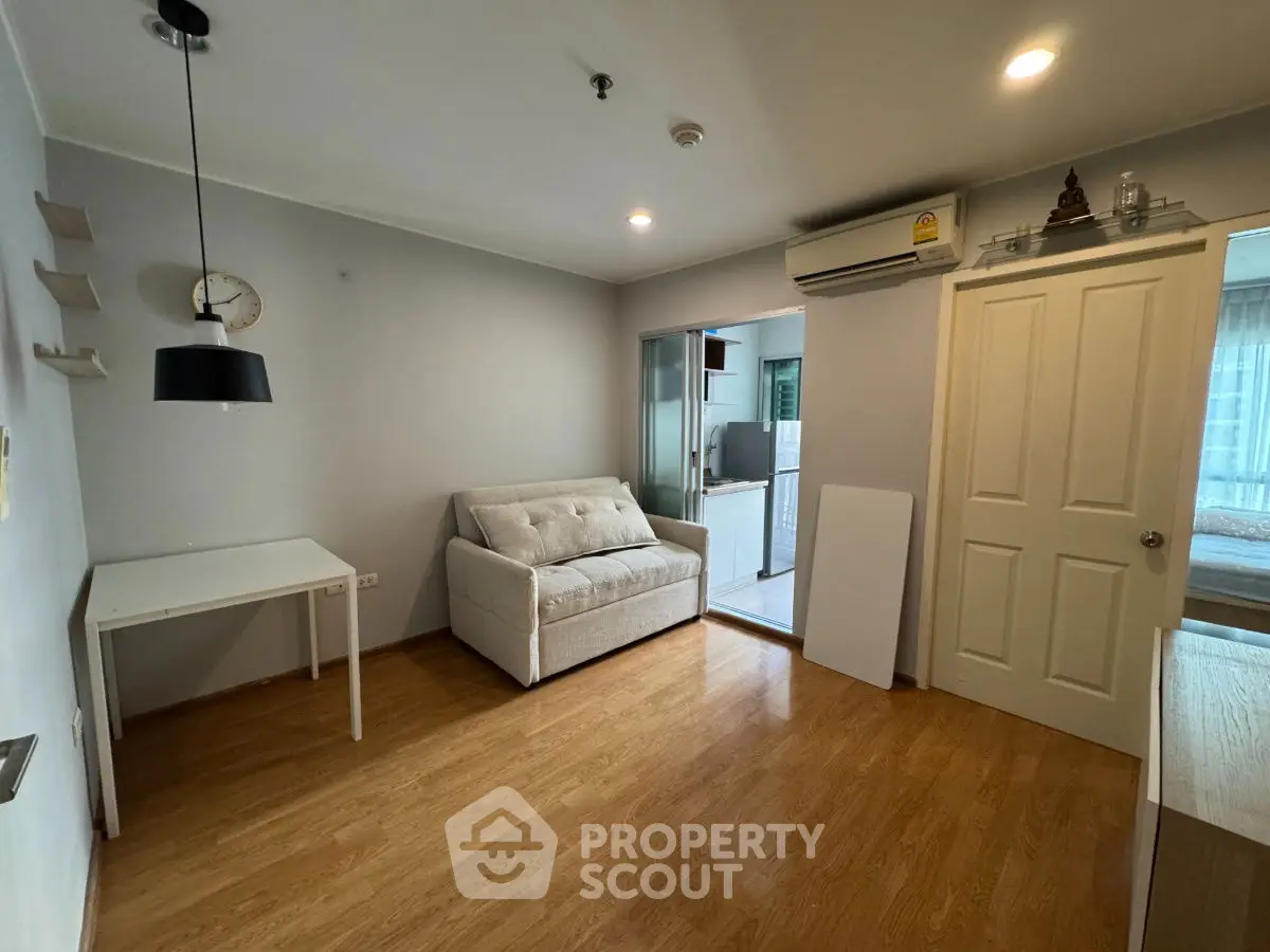 Cozy living room with wooden flooring and modern decor in a stylish apartment.