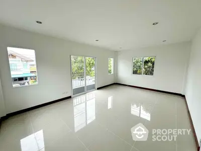 Spacious empty room with large windows and glossy tiled floor