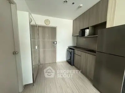 Modern kitchen with sleek cabinetry, washing machine, and stainless steel appliances.