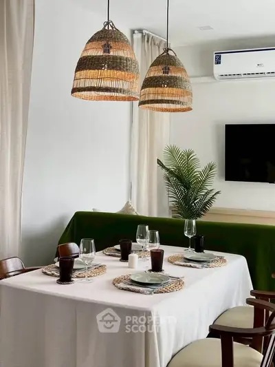 Stylish dining area with elegant table setting and modern decor, featuring wicker pendant lights and air conditioning.