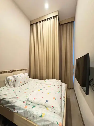 Cozy bedroom with modern decor and wall-mounted TV, perfect for relaxation.