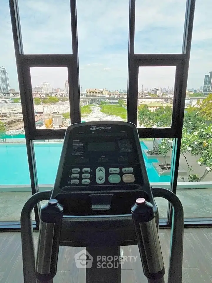 Modern gym with panoramic city view and pool access, perfect for fitness enthusiasts.