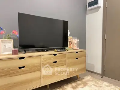 Modern living room with sleek TV stand and flat-screen TV, stylish decor and neutral tones.