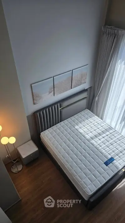 Spacious bedroom with high ceiling and large window for natural light