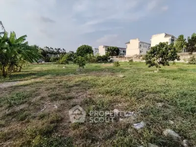 Spacious residential plot with lush greenery and nearby modern homes, ideal for building your dream house.