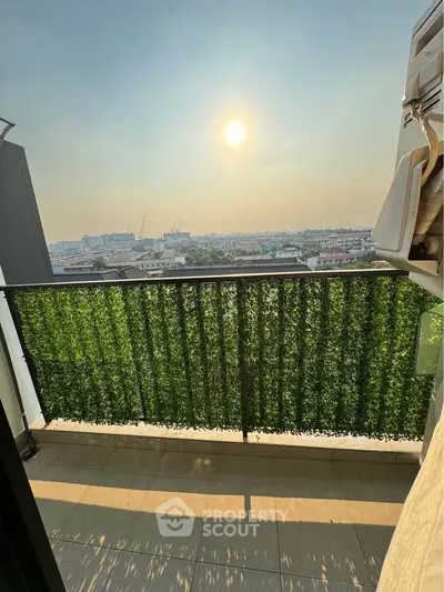 Stunning balcony view with lush greenery and cityscape under a bright sun.