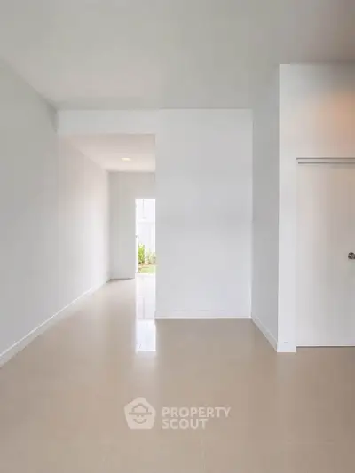 Spacious minimalist interior with neutral tones and natural light, perfect for modern living.