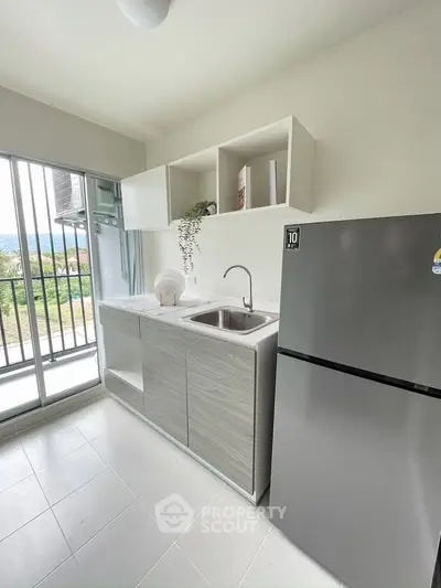 Modern kitchen with sleek design, featuring stainless steel fridge and open shelving, offering a bright and airy atmosphere.