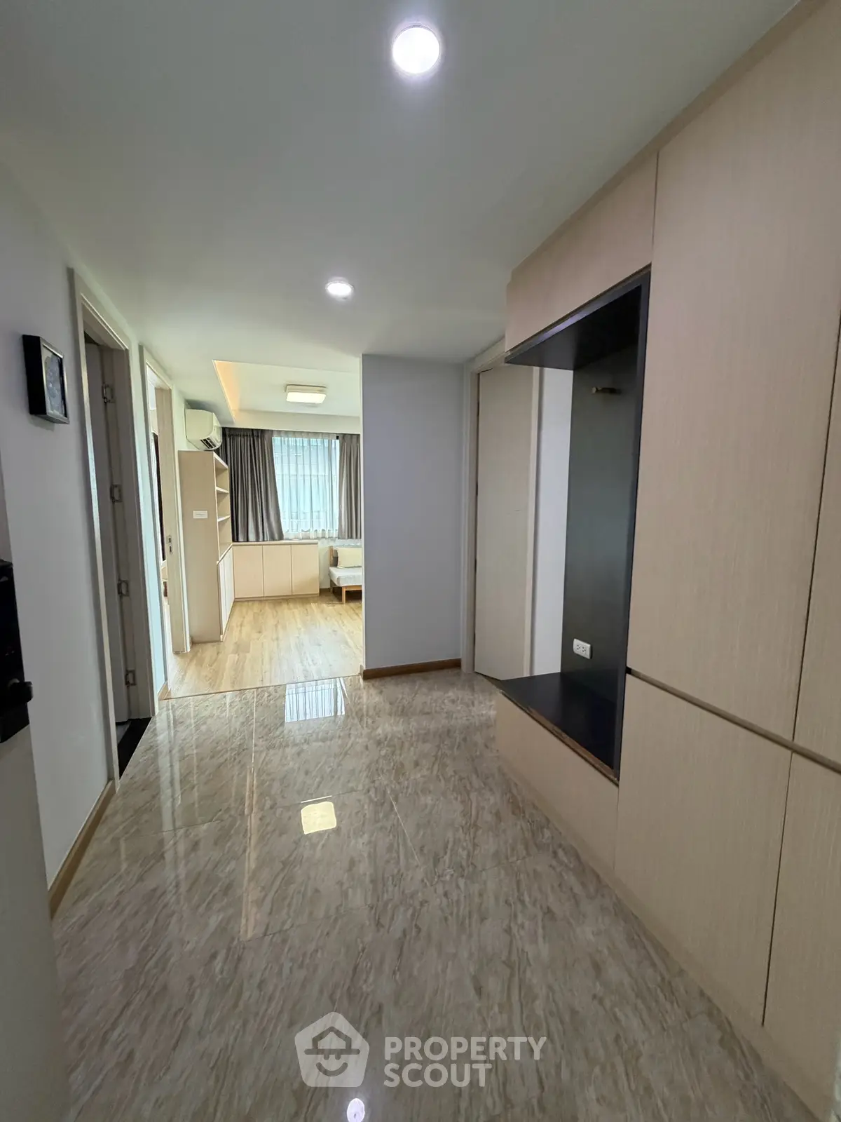 Spacious hallway leading to a bright living area with modern finishes and ample natural light.