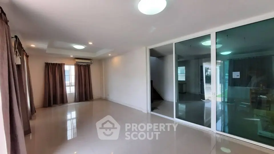 Spacious living room with large windows and modern lighting