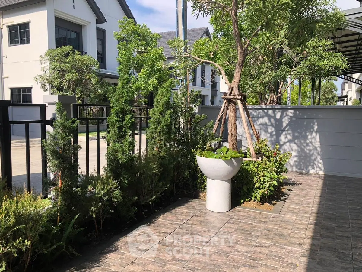 Charming garden patio with lush greenery in modern residential area.