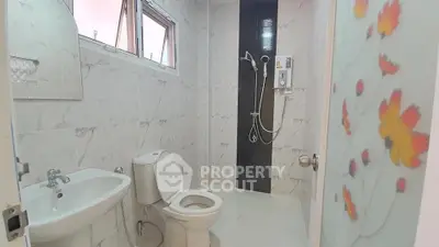 Modern bathroom with sleek fixtures and floral glass door