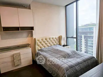 Modern bedroom with large window and stylish furniture in high-rise apartment.
