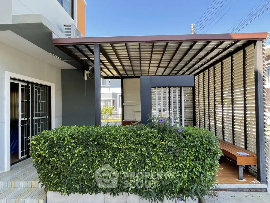 Modern exterior with covered patio and lush greenery, perfect for relaxation.