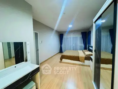 Spacious modern bedroom with elegant decor and large windows for natural light.