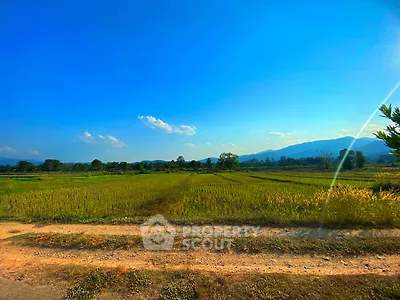 Expansive rural landscape with clear blue sky and distant mountains, perfect for serene living.