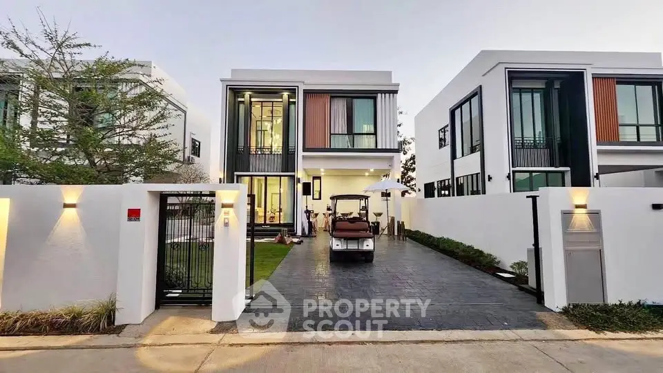 Modern two-story house with sleek design and spacious driveway in a serene neighborhood.