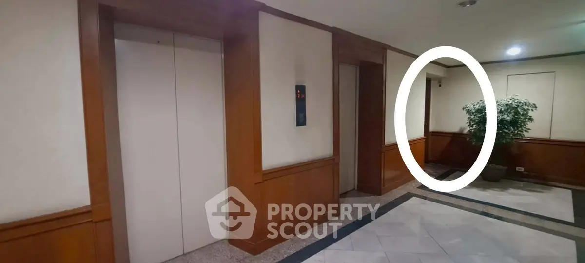 Elegant building elevator lobby with wood paneling and potted plant