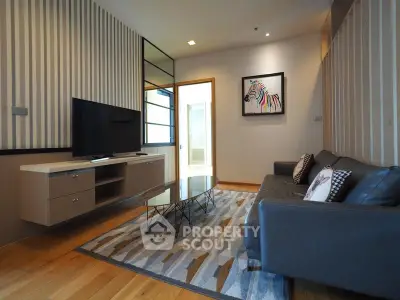 Modern living room with stylish decor, featuring a sleek TV setup and contemporary furniture.