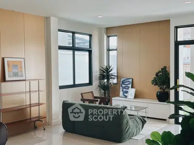 Modern living room with stylish furniture and large windows, offering a bright and inviting atmosphere.