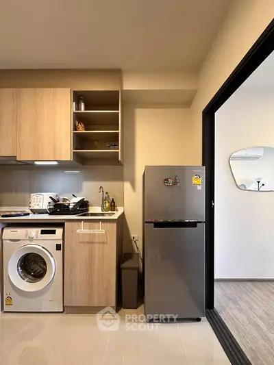 Modern kitchen with washing machine and fridge in stylish apartment