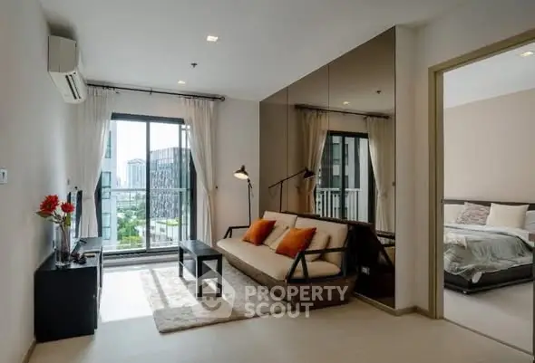 Modern living room with balcony view and cozy bedroom in open layout apartment.