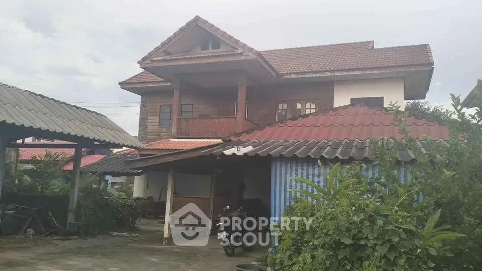Charming two-story house with traditional architecture and lush greenery.