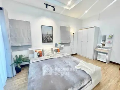 Spacious modern bedroom with stylish decor and ample natural light