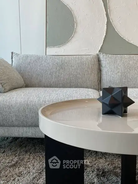 Modern living room with stylish sofa and geometric decor on coffee table.