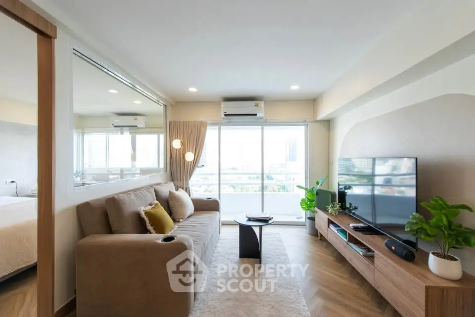 Modern living room with large window, stylish furniture, and natural light.