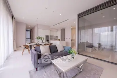 Spacious modern living room with open kitchen and elegant decor in luxury apartment.