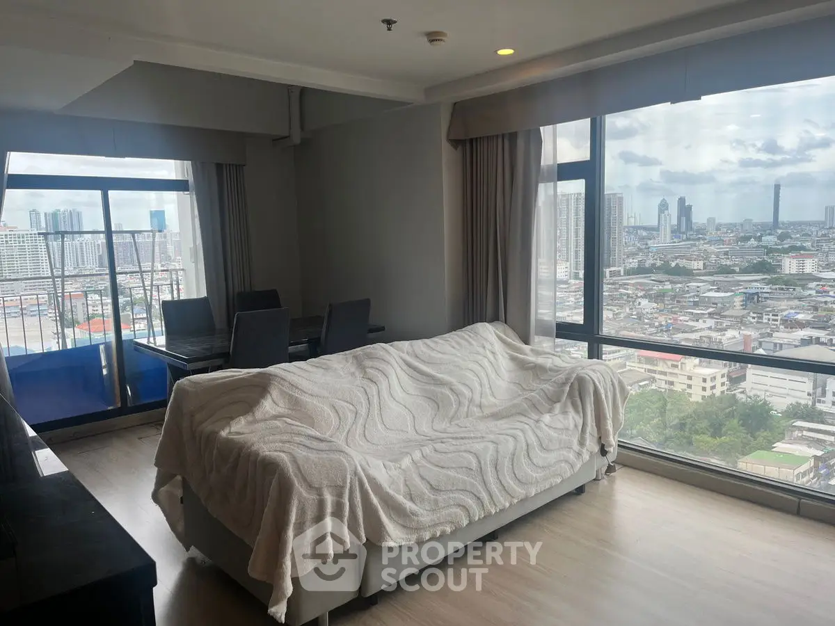 Spacious living room with panoramic city views and modern furnishings.