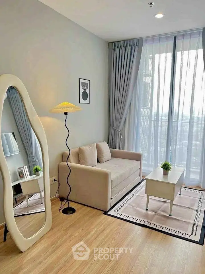 Modern living room with stylish decor and floor-to-ceiling windows offering city views.