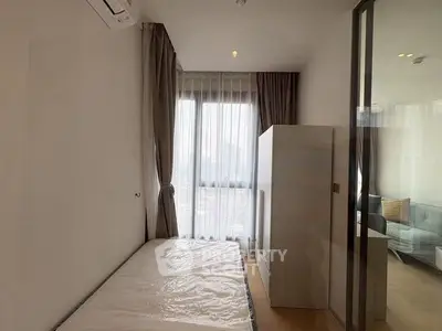 Cozy bedroom with large window and modern furnishings in a stylish apartment.