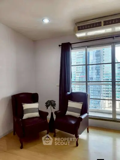 Cozy corner with two armchairs and city view from window in modern apartment.