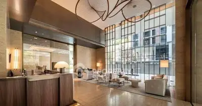Luxurious modern lobby with high ceilings and elegant seating area in upscale building.