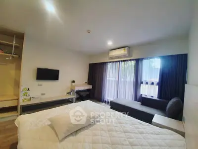 Modern bedroom with large window, cozy bed, and stylish decor in a bright apartment.