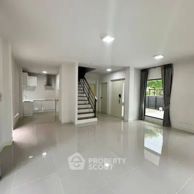 Spacious modern living room with open layout and sleek staircase