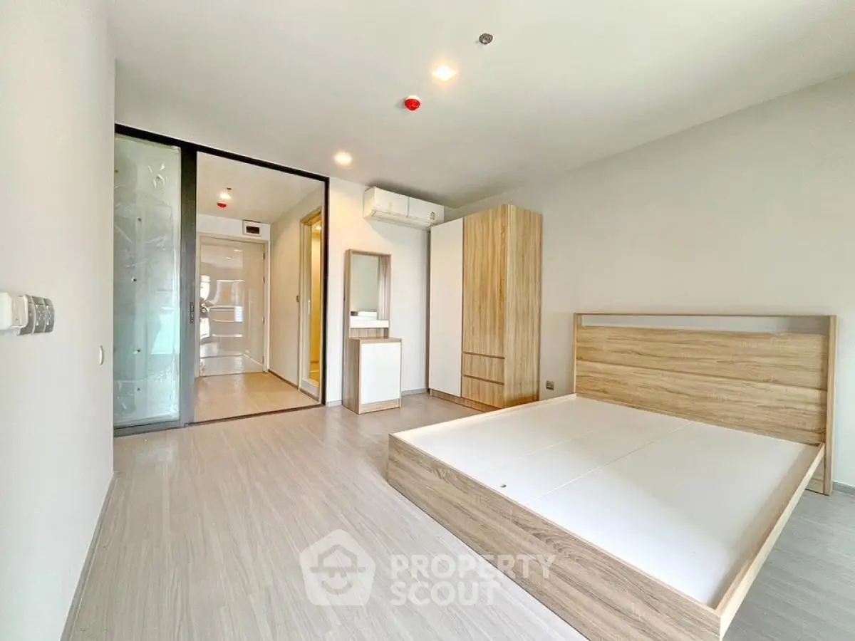 Spacious modern bedroom with wooden flooring and minimalist design